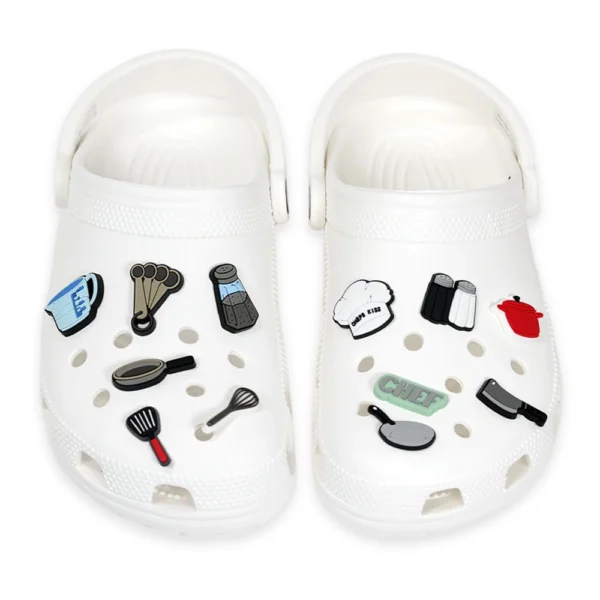 White footwear decorated with cooking-themed charms, including a chef's hat, frying pan, salt & pepper shakers, and kitchen utensils.