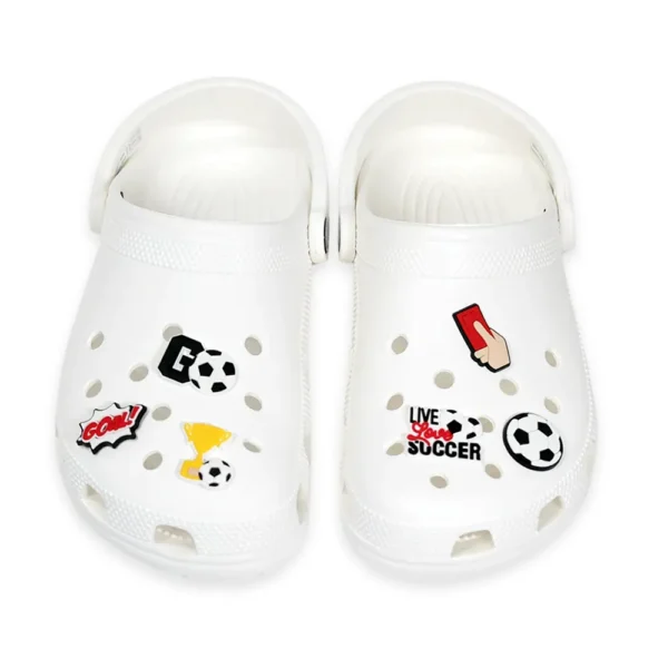 White footwear decorated with soccer-themed charms, including a red card, goal celebration sign, trophy, soccer ball, and "Live Love Soccer" text.