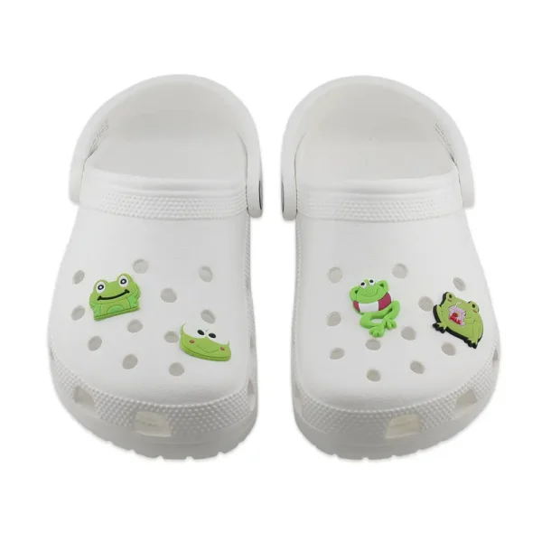 Kawaii frog charms on white Crocs – cartoon-style, pastel green amphibians